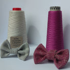 Raspberry Woven Dog Bow Tie in front of yarn cones